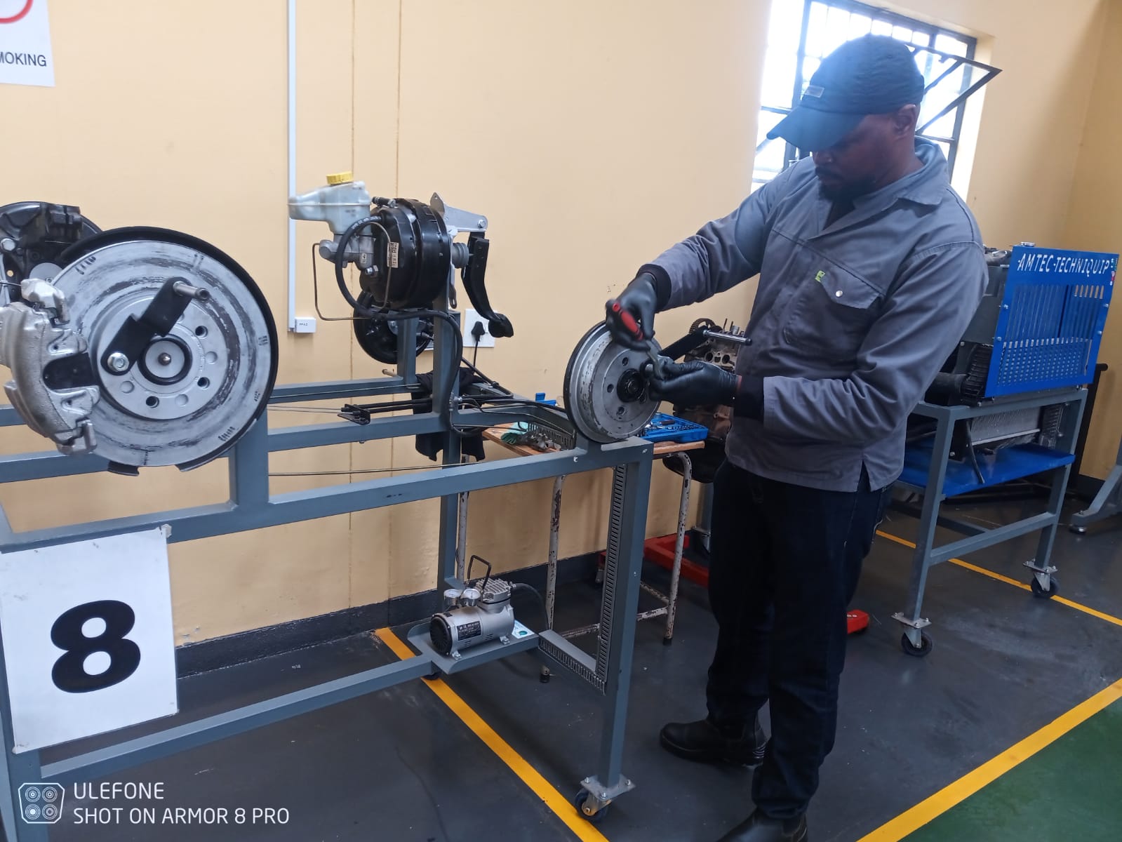 Artisan performing brake system practical assessment